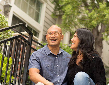 Couple enjoying time outside their home, symbolizing financial security and peace of mind