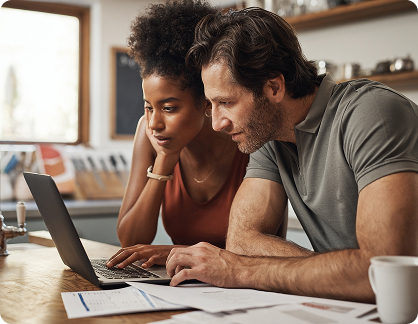 Couple reviewing finances together at home on laptop